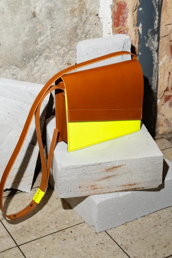 Cognac Reese W. handtas met fluogeel front, cognac riem en fluogele passant.