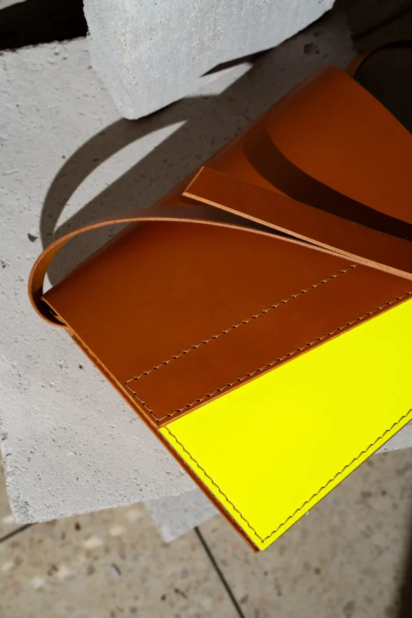 Detail van de cognac Reese W. handtas met fluogeel front.