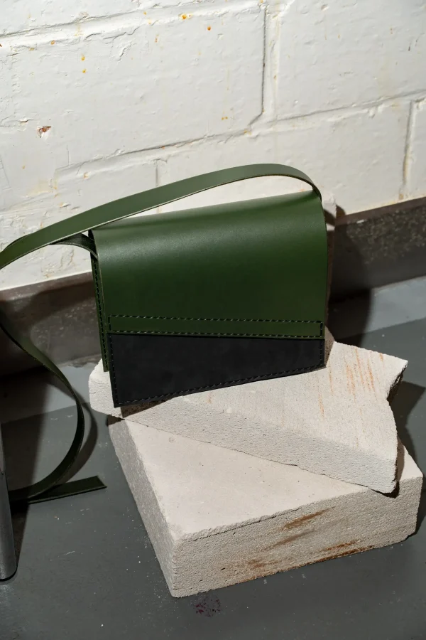 Groene Reese W. handtas met zwart mat front en groene riem.