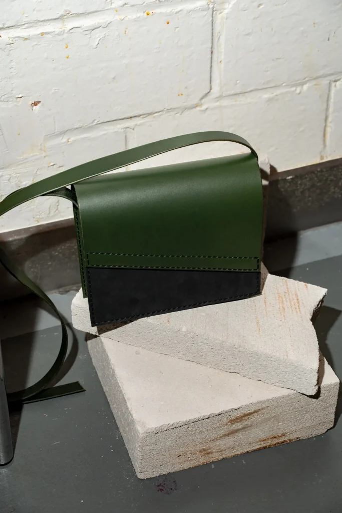 Groene Reese W. handtas met zwart mat front en groene riem.