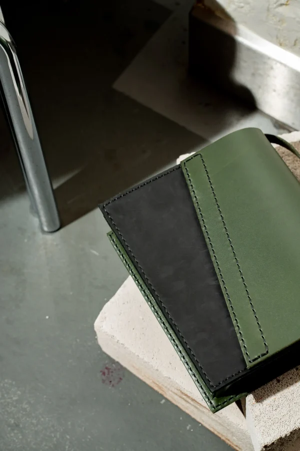 Groene Reese W. handtas met schuine flap en zwart mat front.